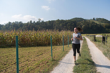 Image showing woman jogging along a country road