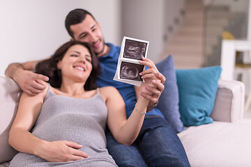 Image showing pregnant couple looking baby\'s ultrasound