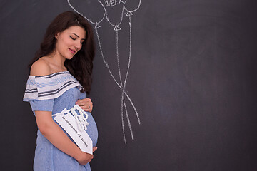 Image showing Portrait of pregnant woman in front of black chalkboard