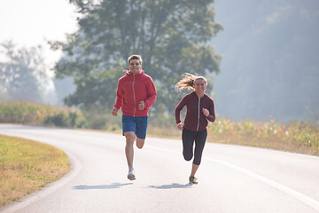 Image showing young couple jogging along a country road