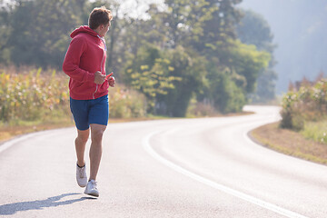 Image showing man jogging along a country road