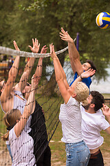 Image showing group of young friends playing Beach volleyball