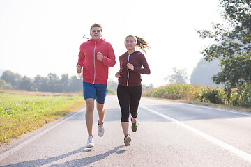 Image showing young couple jogging along a country road