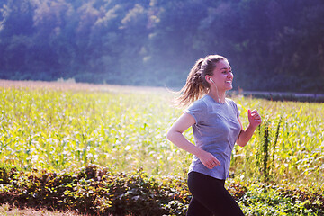 Image showing woman jogging along a country road