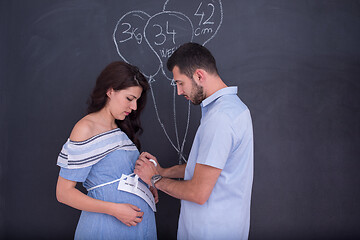 Image showing pregnant couple drawing their imaginations on chalk board