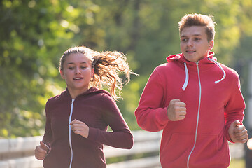 Image showing young couple jogging along a country road