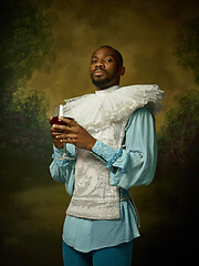 Image showing Young man as a medieval knight on dark background