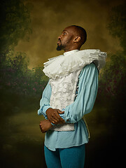 Image showing Young man as a medieval knight on dark background