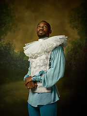 Image showing Young man as a medieval knight on dark background