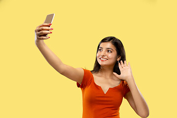 Image showing Portrait of beautiful woman isolated on yellow studio background