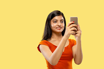 Image showing Portrait of beautiful woman isolated on yellow studio background
