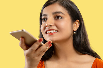 Image showing Portrait of beautiful woman isolated on yellow studio background