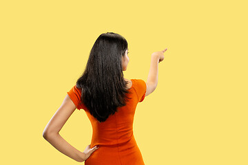 Image showing Portrait of beautiful woman isolated on yellow studio background