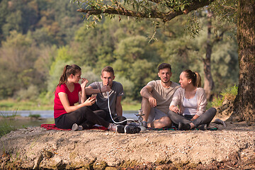 Image showing friends smoking hookah on the river bank