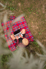 Image showing top view of man using a laptop computer under the tree