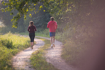 Image showing young couple jogging along a country road