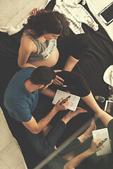 Image showing top view of couple checking a list of things for their unborn ba