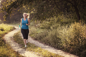 Image showing woman jogging along a country road