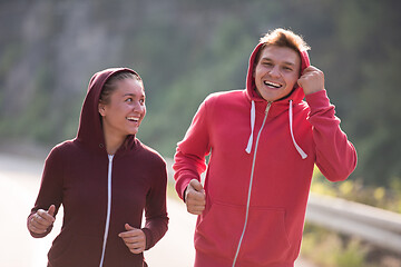 Image showing young couple jogging along a country road