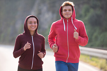 Image showing young couple jogging along a country road