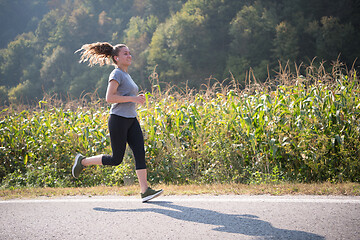 Image showing woman jogging along a country road