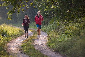 Image showing young couple jogging along a country road