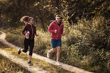 Image showing young couple jogging along a country road