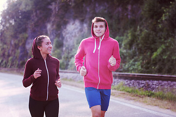 Image showing young couple jogging along a country road