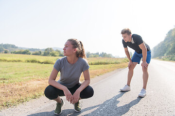 Image showing young couple warming up and stretching on a country road