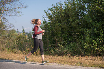 Image showing woman jogging along a country road