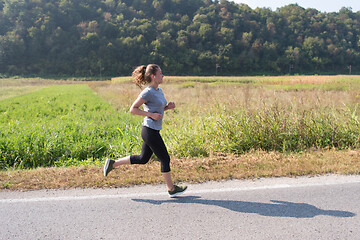 Image showing woman jogging along a country road