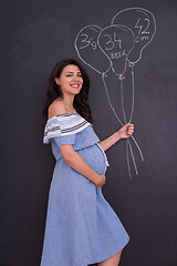 Image showing Portrait of pregnant woman in front of black chalkboard