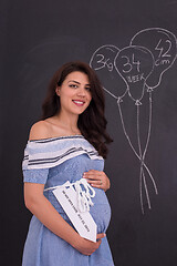 Image showing Portrait of pregnant woman in front of black chalkboard