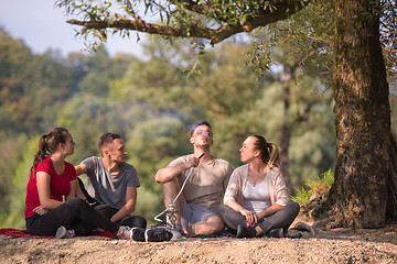 Image showing friends smoking hookah on the river bank