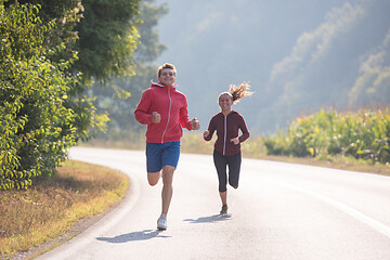 Image showing young couple jogging along a country road