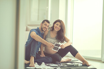 Image showing pregnant couple checking a list of things for their unborn baby