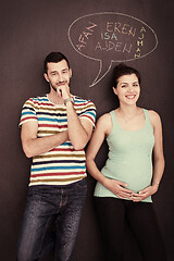 Image showing pregnant couple writing on a black chalkboard