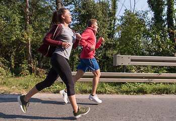 Image showing young couple jogging along a country road