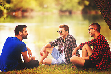 Image showing men sitting on the bank of the river