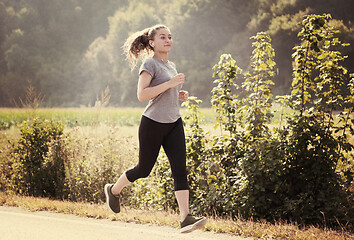 Image showing woman jogging along a country road