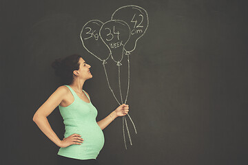 Image showing Portrait of pregnant woman in front of black chalkboard