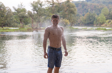 Image showing man with a bare torso splashing water