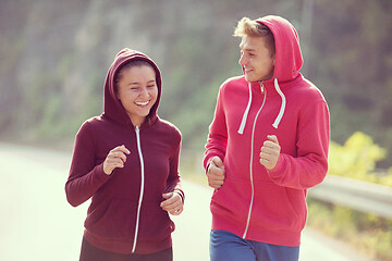 Image showing young couple jogging along a country road