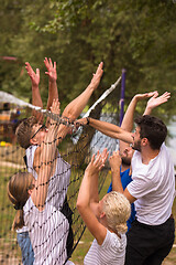 Image showing group of young friends playing Beach volleyball