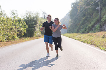 Image showing young couple jogging along a country road