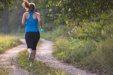 Image showing woman jogging along a country road