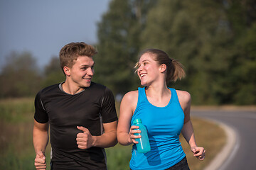 Image showing young couple jogging along a country road