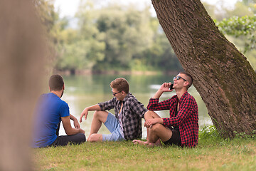 Image showing men sitting on the bank of the river