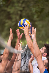 Image showing group of young friends playing Beach volleyball