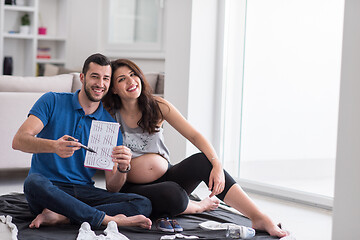 Image showing pregnant couple checking a list of things for their unborn baby